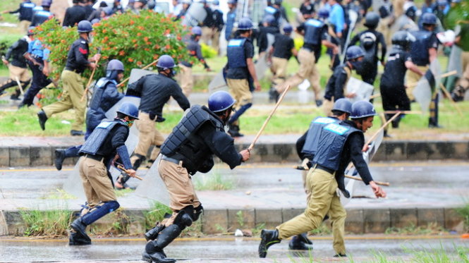 Cảnh sát tháo chạy khi bị người biểu tình tấn công trong một cuộc đụng độ sáng nay - Ảnh: AFP