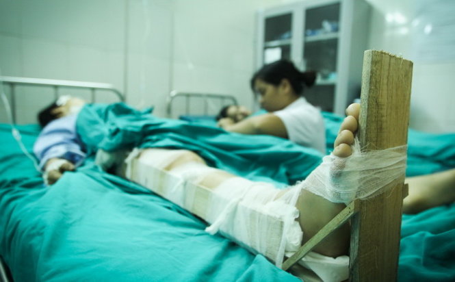Một nạn nhân bị gẫy chân đang được nẹp gỗ cố định vết thương - Ảnh: Nguyễn Khánh