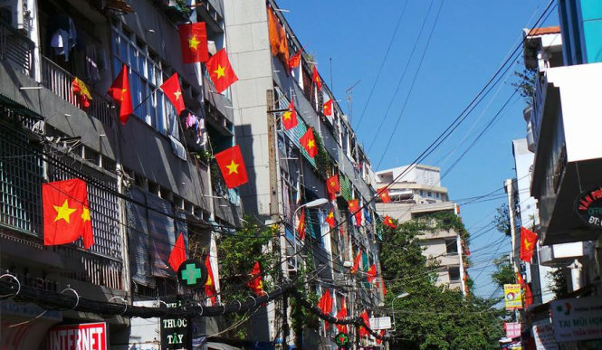 Người dân ở chung cư đường Vũ Huy Tấn (quận Bình Thạnh) treo cờ đỏ sao vàng rực rỡ. - Ảnh: Mỹ Khánh