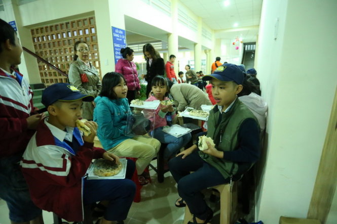 Anh em Trần Tuấn Kiên, Trần Tuấn Cường (lớp học tình thương Donbosco) chia nhau 1 phần bánh, còn một phần mang về chia cho mẹ. Ảnh: MAI VINH