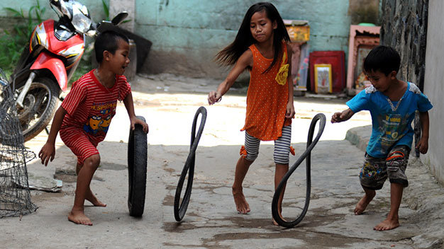  TP.HCM: Những đứa trẻ sống gần kênh Cầu Mé (phường 3, quận 11, TP.HCM) vui đùa cùng những chiếc lốp xe cũ - Ảnh: Nguyễn Quang