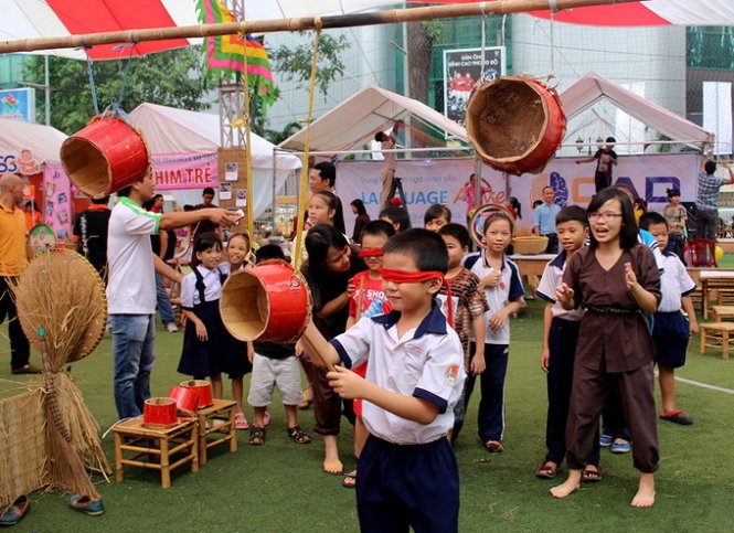 Các em nhỏ chơi bịt mắt ném lon - Ảnh: N.Tuyết