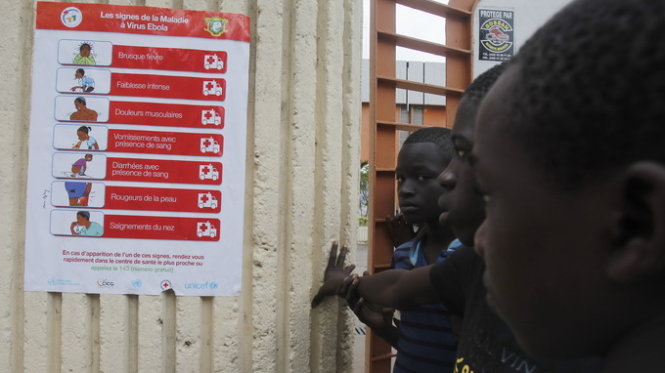 Trẻ em đứng trước một áp phích về dịch Ebola ở Sierra Leone - Ảnh: Reuters