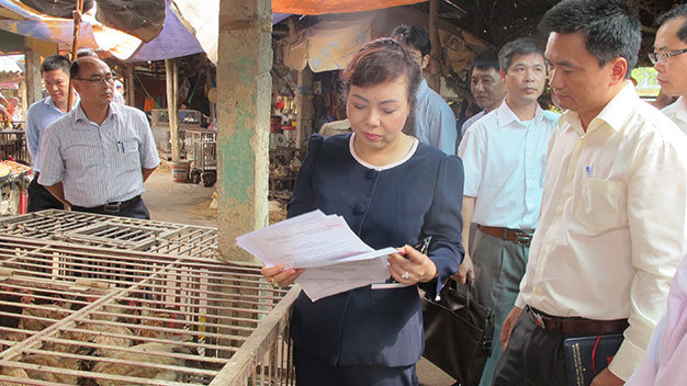 Bộ trưởng Nguyễn Thị Kim Tiến kiểm tra việc mua bán gia cầm tại chợ Giếng Vuông (Lạng Sơn) - Ảnh: L.Anh