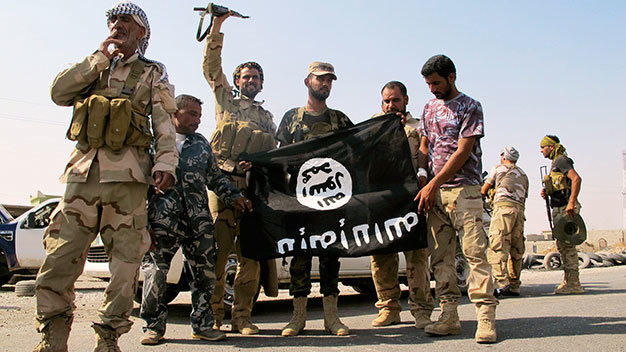 Binh sĩ Iraq và chiến binh người Shiite hạ cờ của IS sau khi giành chiến thắng tại Amerli ngày 1-9 - Ảnh: Reuters