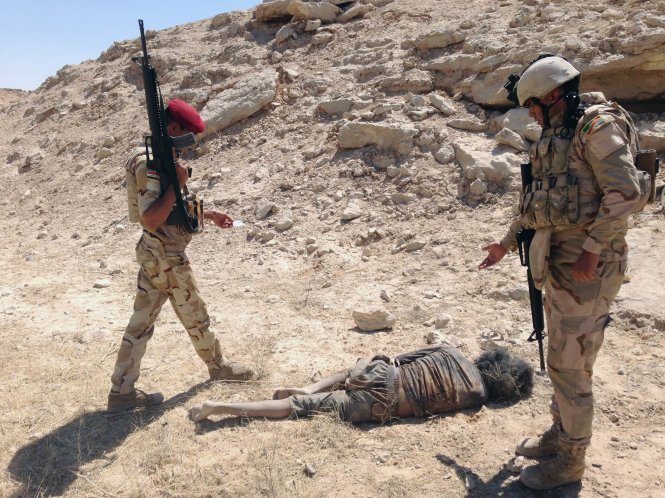 Binh sĩ Iraq xem xét thi thể phiến quân IS thiệt mạng sau cuộc không kích của Mỹ ở ngoại ô Haditha ngày 9-9 - Ảnh: Reuters