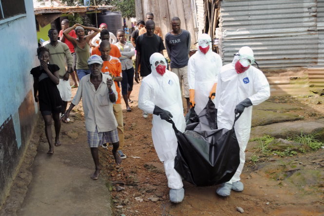 Các nhân viên y tế Liberia di chuyển thi thể một nạn nhân dịch Ebola ở thủ đô Monrovia - Ảnh: Reuters