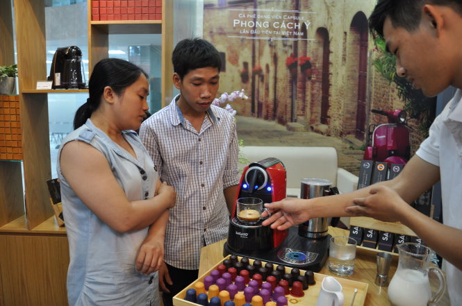 Nhân viên Trần Lê Nhật Hào (bìa phải) pha chế cà phê trên máy pha cà phê của hệ thống Sagaso Caffè Boutique - Ảnh: T.V.N.