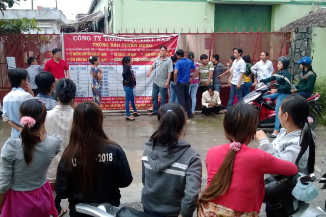 Các công nhân Công ty TNHH SMY VN (H.Hóc Môn) tập trung trước cổng công ty để đòi tiền lương. Đến nay họ vẫn chưa nhận đủ số tiền lương tháng 7 và tháng 8 - 2014 - Ảnh: Q.P.