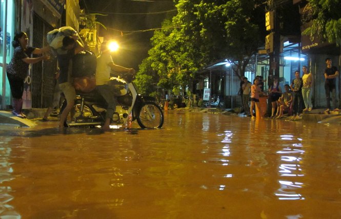 Nhiều gia đình sinh sống trên phố Nguyễn Du đã phải di dời tài sản ngay trong đêm tránh nước ngập - Ảnh Quang Thế 