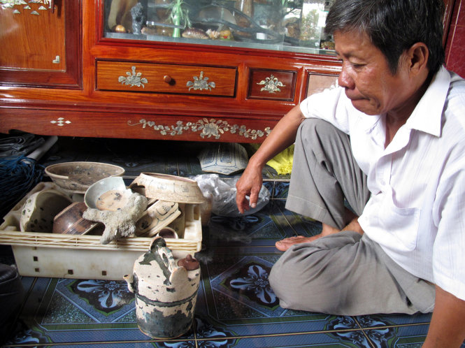 Ngư dân Tư Lành (xã Bình Châu, huyện Bình Sơn, Quảng Ngãi) bên một số hiện vật trục vớt được từ vùng biển Cù Lao Chàm tháng 9-2012 - Ảnh: Thái Lộc
