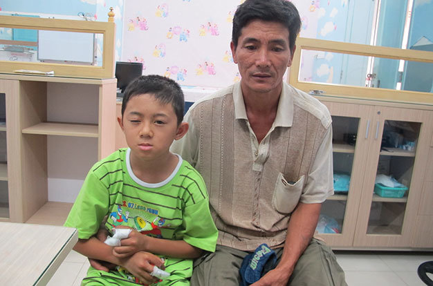 Cháu Tú và cha tại Bệnh viện Mắt TP.HCM - Ảnh: Thùy Dương