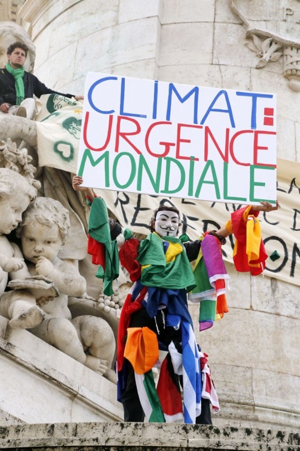 Một người dân giơ cao biểu ngữ tại cuộc diễu hành ở Paris, Pháp - Ảnh: AFP
