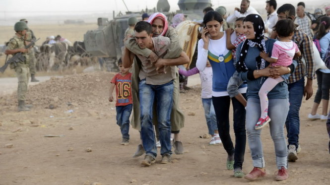 Người Kurd từ Syria tràn qua biên giới Thổ Nhĩ Kỳ để lánh nạn - Ảnh: Reuters