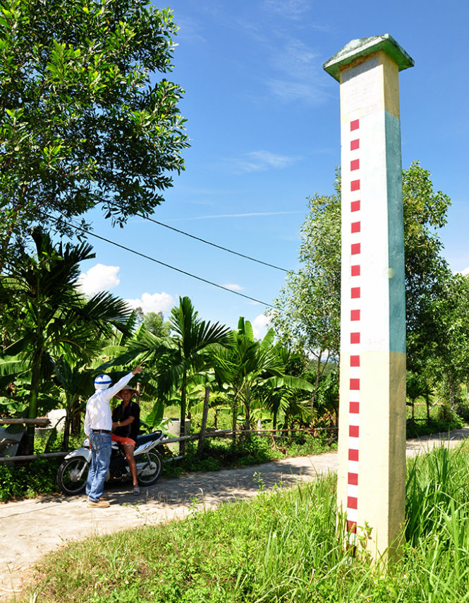 Cột mốc báo lũ ở đầu làng Phước Châu còn đánh dấu và ghi rõ trận lũ lịch sử năm 1999 như để nhắc nhở dân làng - Ảnh: Tấn Vũ