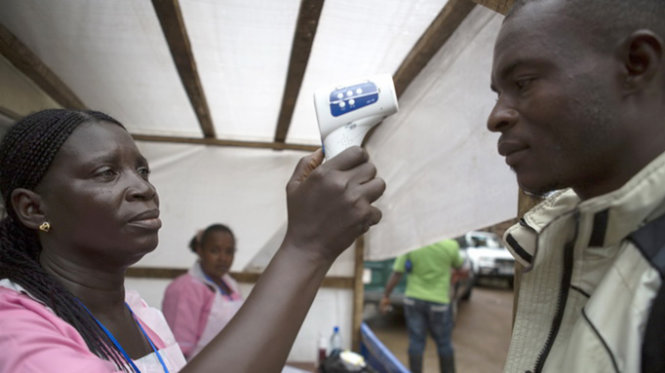 Một nữ y tá đo nhiệt độ nhân viên hoạt động xã hội ở Freetown, thủ đô Sierra Leone - Ảnh: Reuters