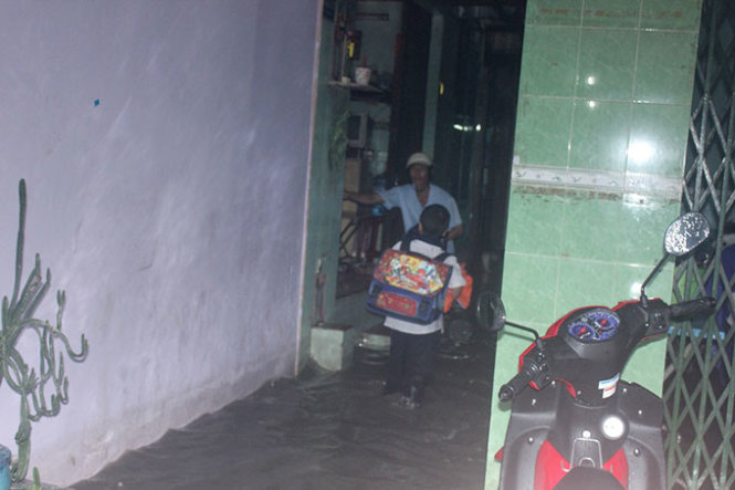 Một em học sinh lội nước về nhà ở hẻm 83 đường Tân Hòa Đông - Ảnh : Đức Phú