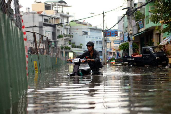 Nước ngập gần đến yên xe trên đường Tân Hóa. Ảnh: Hữu Khoa