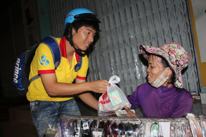 Sinh viên ĐH Bách khoa (ĐHQG TP.HCM) thuộc chiến dịch Xuân tình nguyện trao quà cho người nghèo trên đường phố đêm khuya dịp  Tết 2014 - Ảnh: Phước Tuần