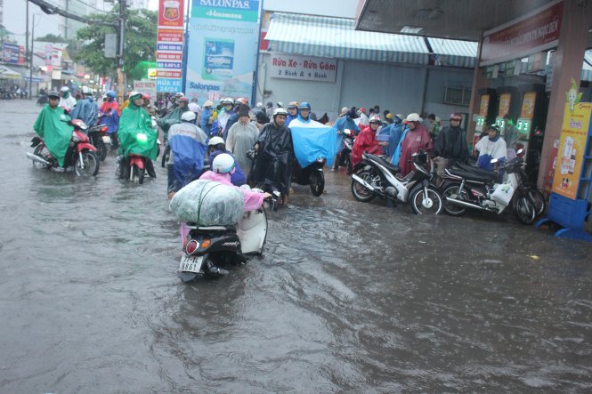 Người dân trú tạm ở cây xăng chờ nước rút. Ảnh: Đức Phú