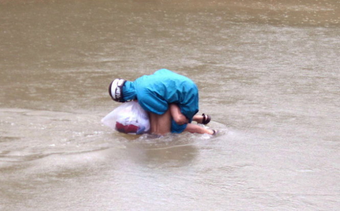 Hình ảnh phụ huynh liều mình đưa con qua suối đến trường - Ảnh: Ngọc Dương