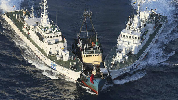 Tàu cá Trung Quốc (giữa) bị hai tàu tuần duyên của Nhật vây ép tại đảo Uotsuri  thuộc quần đảo Senkaku/Điếu Ngư mà Nhật đang quản lý - Ảnh: AFP