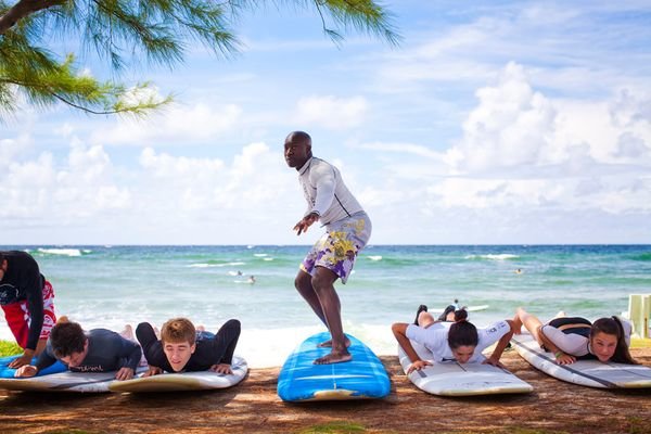 Bắt sóng ghi lại khoảnh khắc tuyệt đẹp của một thầy giáo dạy các học viên trong buổi học lướt sóng ở Barbados - Ảnh: National Geographic