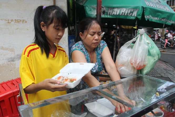 Xuân phụ mẹ bán bánh bèo sau giờ đi tập bóng về - Ảnh: Nguyễn Ngoãn