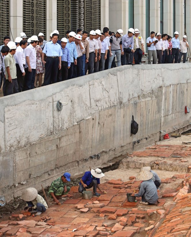 Thủ tướng Nguyễn Tấn Dũng chứng kiến cảnh công nhân khảo cổ lau rửa các hiện vật dưới hố khảo cổ thuộc di tích hoàng thành Thăng Long trước khi các hố này tạm thời được lấp cát để bảo vệ - Ảnh: Việt Dũng