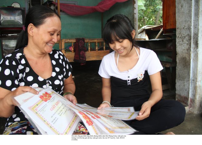 Hồng Nhung và mẹ bên những giấy khen của Nhung - Ảnh: Đoàn Cường