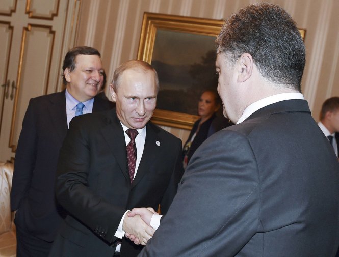 Tổng thống Nga Vladimir Putin bắt tay tổng thống Ukraine tại cuộc họp bên lề hội nghị ASEM ngày 17-10 - Ảnh: Reuters