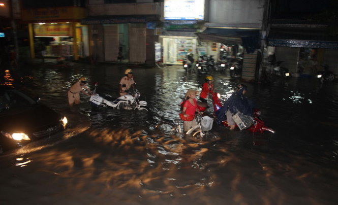 Người dân loay hoay với ngập nước trên đường Tân Hóa. Ảnh: Đức Phú