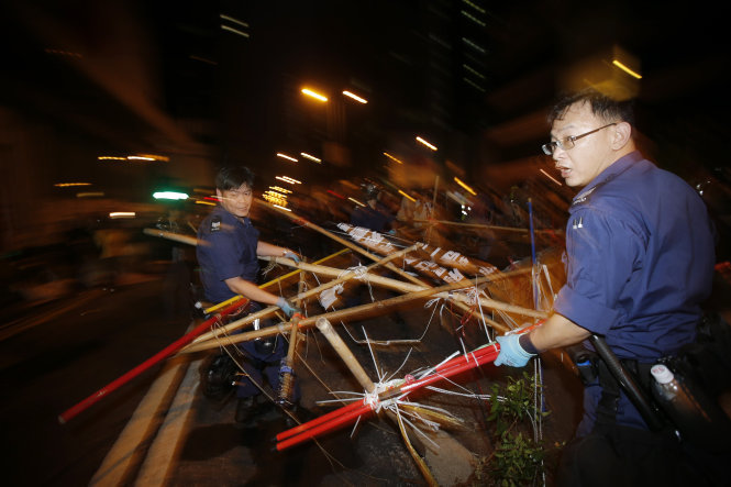 Cảnh sát dọn dẹp rào cảnh của người biểu tình tại khu vực Mongkok - Ảnh: Reuters