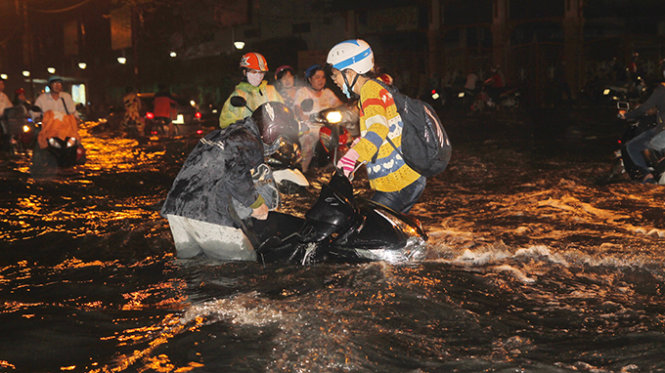 Người chạy xe té ngã do ngập sâu trên đường Kinh Dương Vương (Q.Bình Tân, TP.HCM) - Ảnh: Hữu Khoa