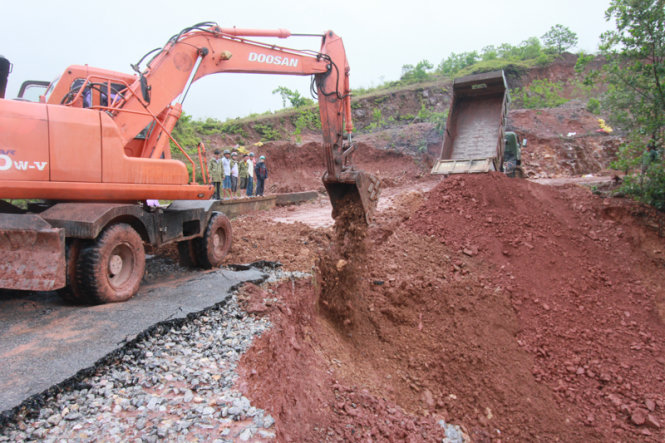 Chính quyền địa phương huy động ô tô, máy xúc gia cố đoạn đập bị vỡ – Ảnh: Tiến Thắng