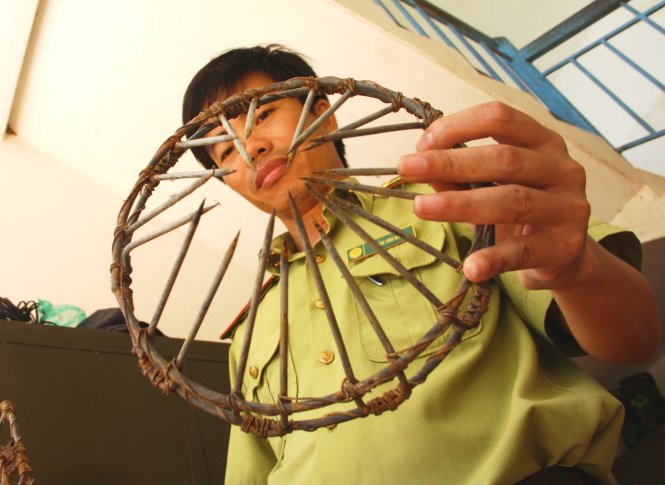 Anh Trần Văn Bình, hạt phó hạt kiểm lâm Vườn quốc gia Nam Cát Tiên, bên chiếc bẫy thép có thể cùm nát chân bò tót - Ảnh: Viễn Sự