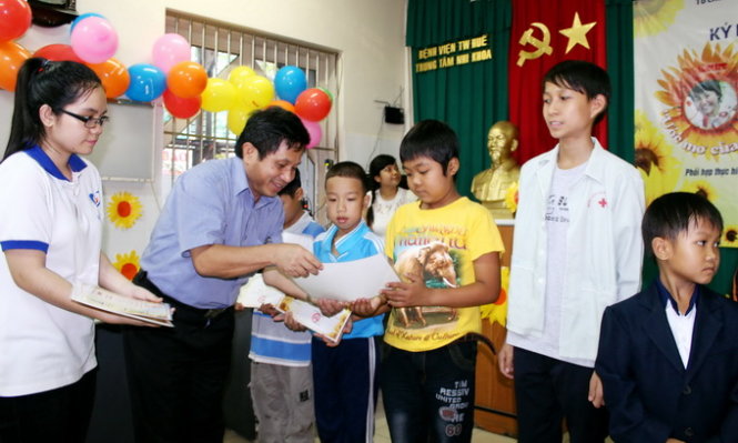 Lãnh đạo khoa Nhi bệnh viện Trung ương Huế trao học bổng cho các em thiếu nhi - Ảnh: Ngọc Dương
