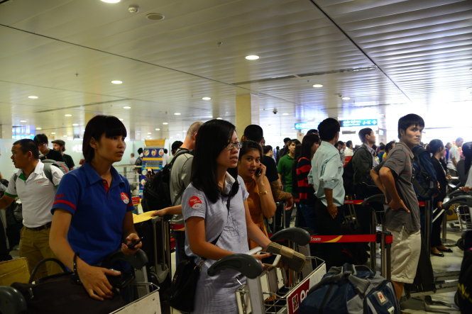 Hành khách làm thủ tục lên máy bay tại nhà ga Tân Sơn Nhất, TP.HCM - Ảnh: Hữu Khoa