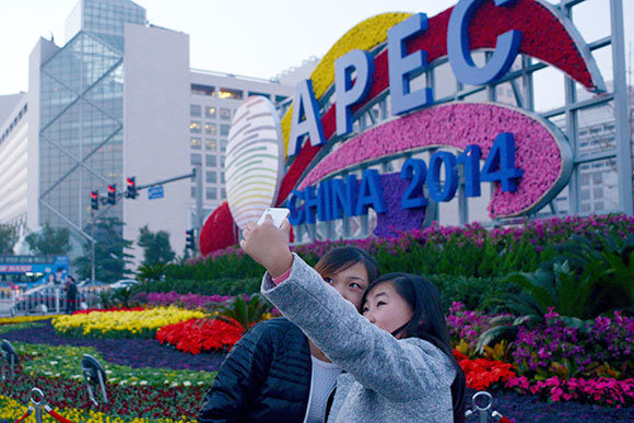 Tự chụp ảnh lưu niệm trước một nơi quảng bá Hội nghị thượng đỉnh APEC ở thủ đô Bắc Kinh (Trung Quốc) ngày 8-11 - Ảnh: AFP