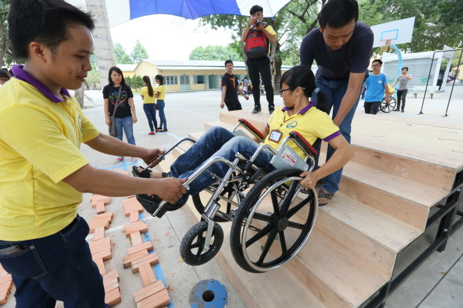 Các tình nguyện viên, sinh viên thử trải nghiệm khó khăn của người khuyết tật để ý thức hơn trong việc giúp đỡ người khuyết tật hằng ngày - Ảnh: D.Nguyễn