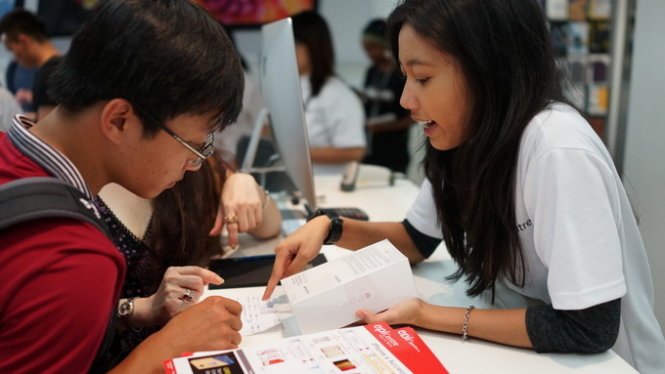 Một người Việt chọn mua iPhone 6 chính hãng tại cửa hàng Apple Store ở Singapore - Ảnh: Thuận Thắng