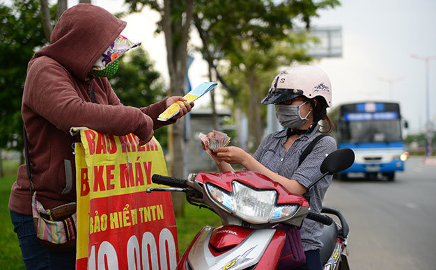 Bán bảo hiểm xe máy và ôtô trên xa lộ Hà Nội (đoạn qua P.An Phú, Q.2, TP.HCM) - Ảnh: Hữu Khoa