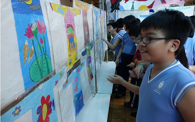 Học sinh Trường tiểu học Lương Định Của Q.3, TP.HCM thích thú xem triển lãm thiết kế áo dài do các bạn cùng trường vẽ nhân Ngày nhà giáo VN - Ảnh: Như Hùng