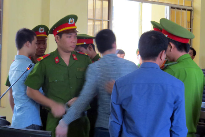 Các cảnh sát bảo vệ ngăn chặn hành vi đạp vào ghế tại hội trường xử án của bị cáo Lê Minh Phát (thứ ba từ phải sang) - Ảnh: DUY THANH