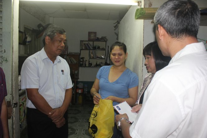Ông Nguyễn Thành Chung, giám đốc Sở Giao thông vận tải TP (bên trái) hỏi thăm sức khỏe gia đình chị Lương Thị Hiệp (Q.Bình Thạnh. Ảnh: Đức Phú