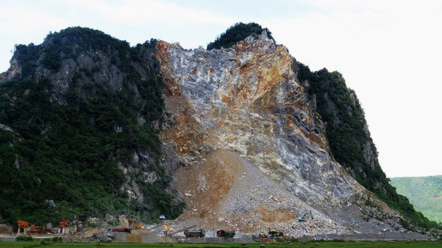Từ một ngọn núi rất đẹp trên tuyến quốc lộ 12A, núi Cây Trỗ  (xã Thạch Hóa, huyện Tuyên Hóa) đã tan nát sau hơn một năm  được cấp phép khai thác đá xây dựng - Ảnh: Quốc Nam