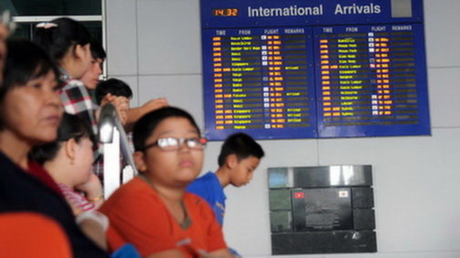 Thân nhân hành khách đợi ở sân bay Tân Sơn Nhất trong lúc vẫn còn nhiều chuyến bay chưa xếp được lịch hạ cánh (ảnh chụp lúc 13g55 ngày 20-11) - Ảnh: Mậu Trường