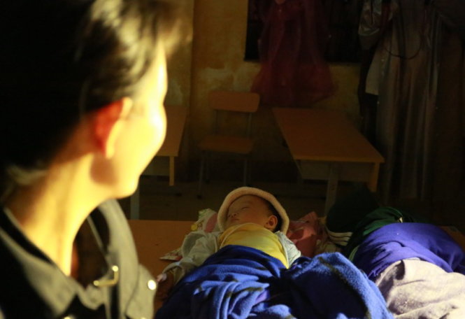 Chị Huỳnh Thị Diễm chăm sóc hai con nhỏ tránh bão đêm 29-11 tại trường mẫu giáo Xuân Lâm - Ảnh: Tiến Thành