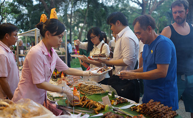 Khách tham quan thưởng thức món nướng của nhà hàng Đầm Sen  (TP.HCM) tại Liên hoan ẩm thực các nước tối 4-12 - Ảnh: Thuận Thắng