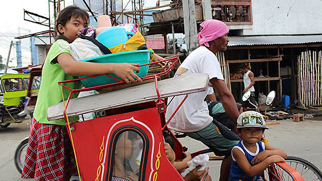 Người dân ở Tacloban lên đường sơ tán với ít ỏi đồ đạc vào ngày 4-12 - Ảnh: Reuters